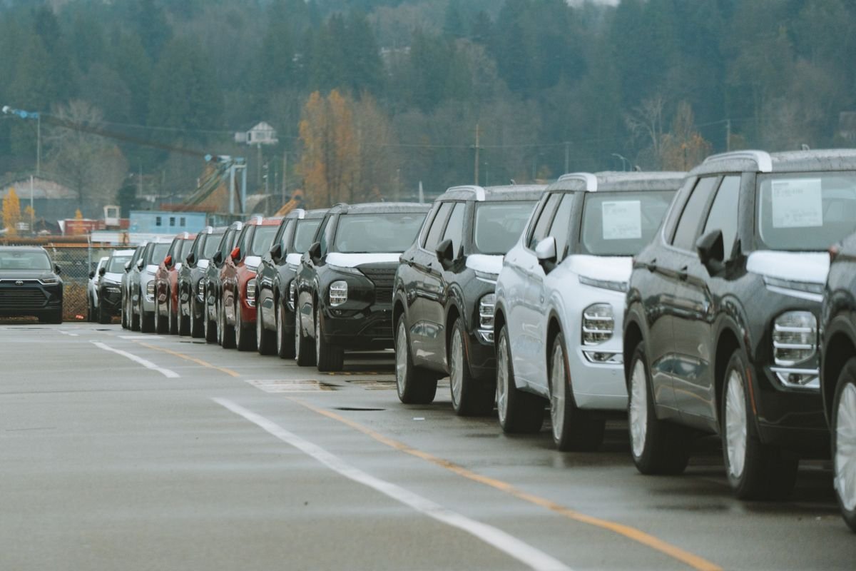 Fileiras de carros em pátio de concessionária, contexto de negociação de cotas de consórcio
