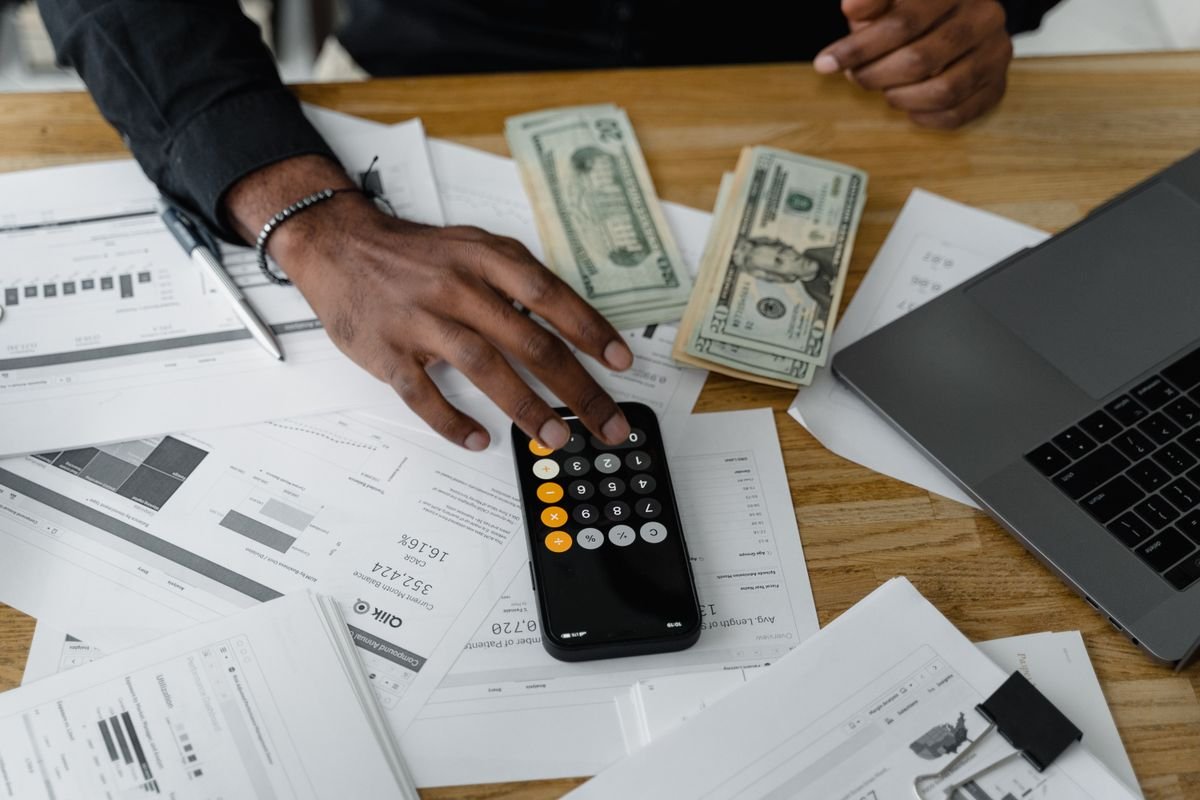 Pessoa usando calculadora para simular financiamento com score de crédito baixo